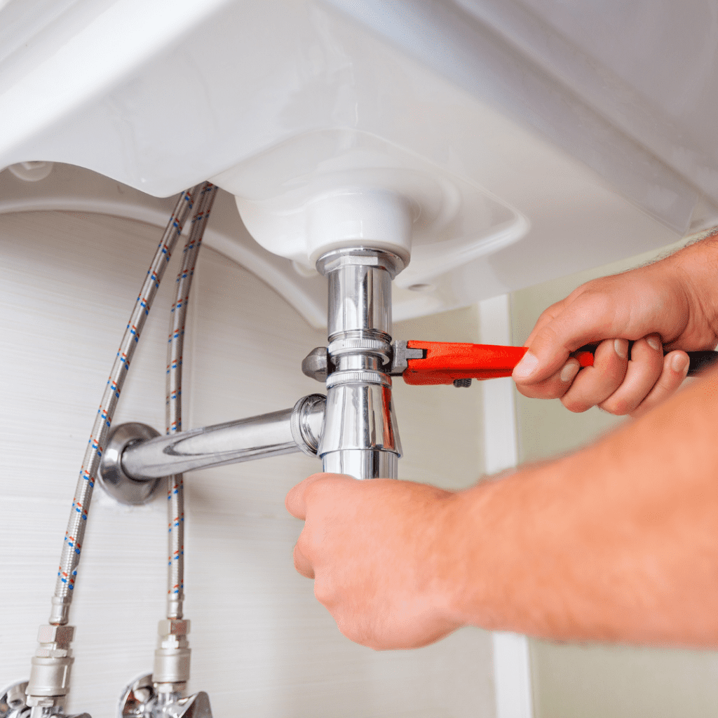 photo of plumber fixing pipes in bathroom