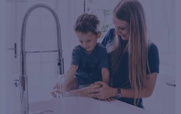 Mother and Son Washing Their Hands Together in a Kitchen Sink.