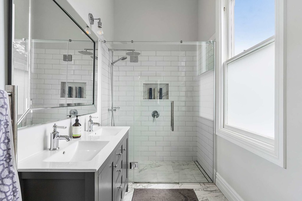Bright bathroom with a double vanity and walk-in shower Bright bathroom with a double vanity and walk-in shower